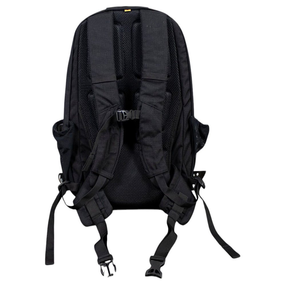 Back of a black backpack with padded straps and buckles.