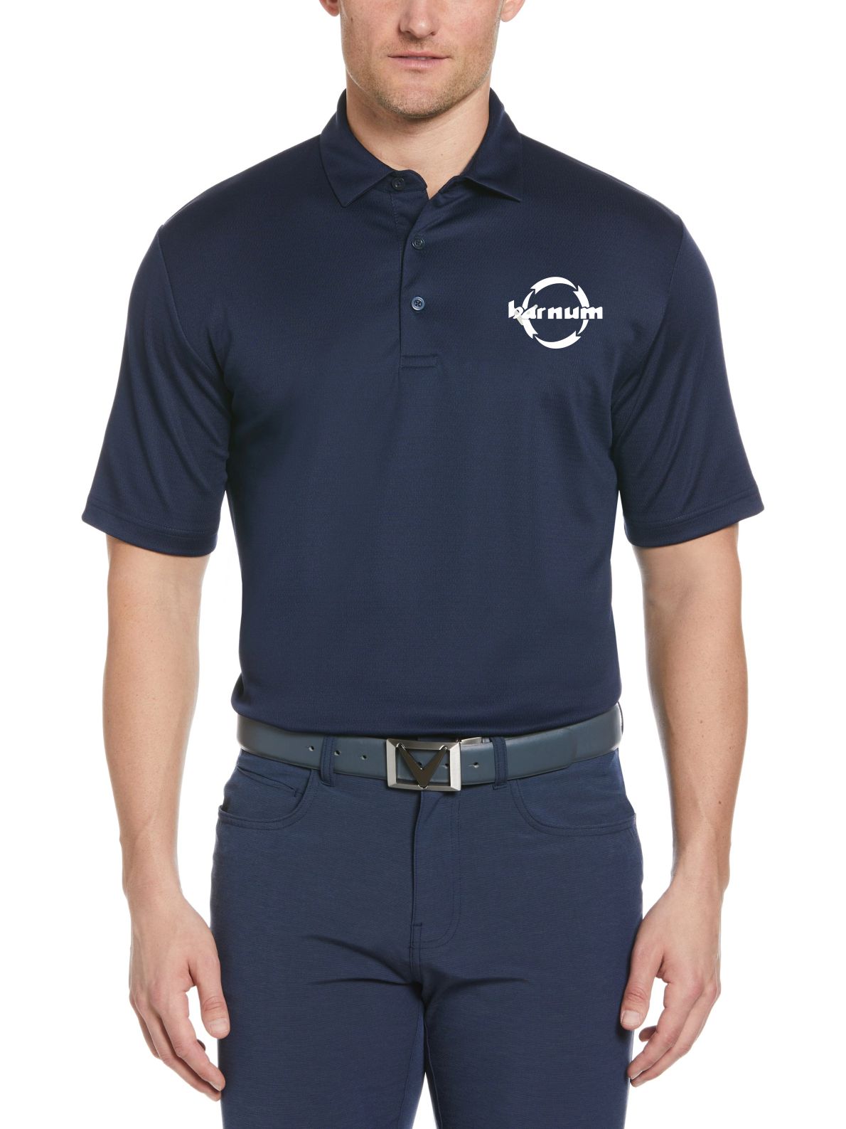 A man wearing a navy blue polo shirt with a logo on the left chest and matching navy pants.
