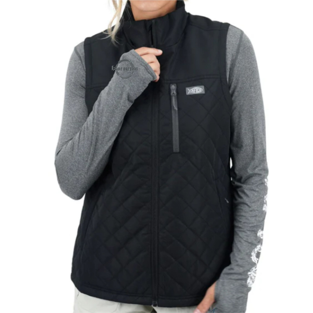 Woman wearing a black quilted vest over a long-sleeve gray top
