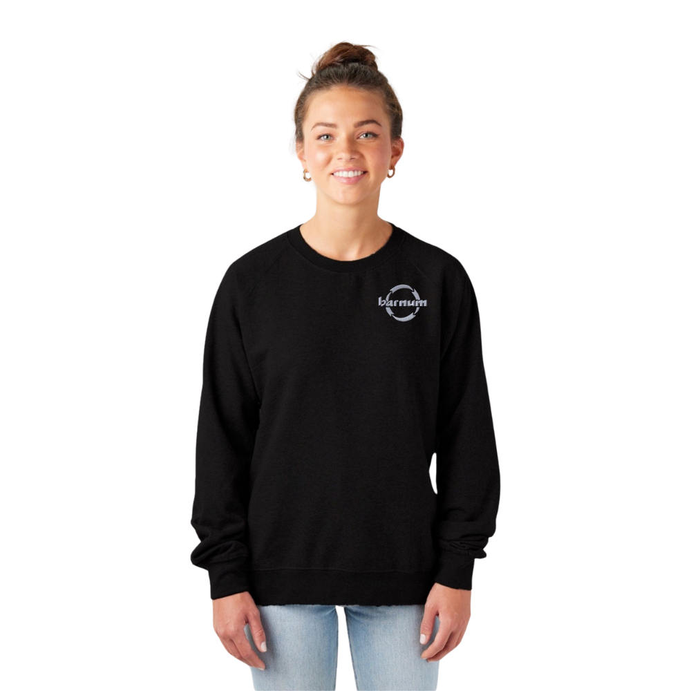 A smiling woman wearing a black sweatshirt with a logo on the chest